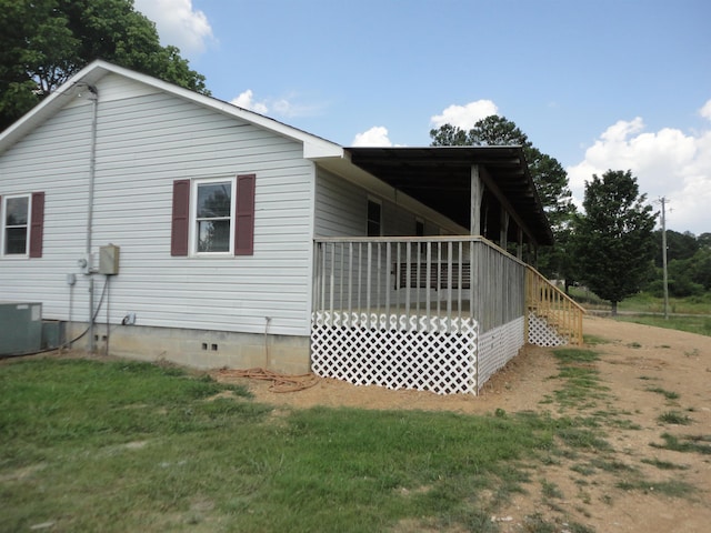 view of home's exterior with cooling unit and a lawn