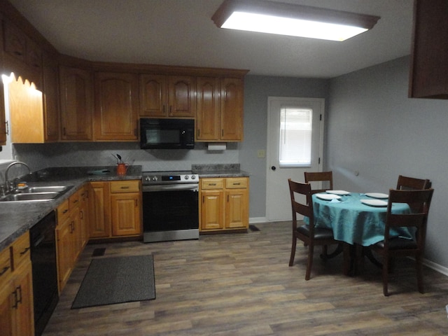 kitchen with black appliances, dark hardwood / wood-style floors, and sink