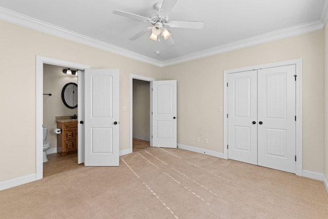 unfurnished bedroom featuring ceiling fan, crown molding, ensuite bathroom, and light carpet