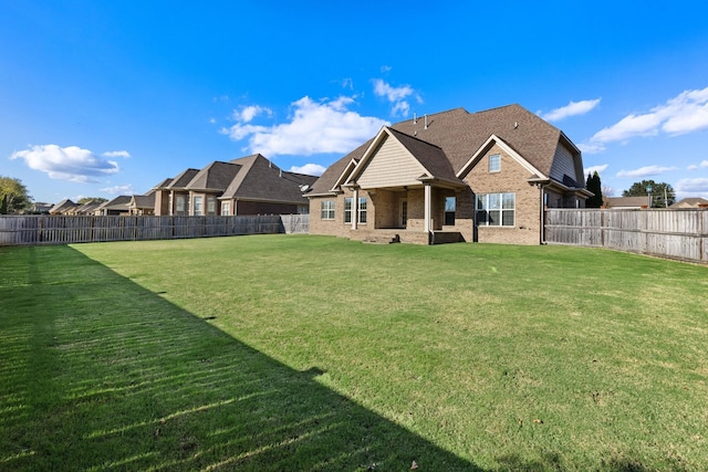 rear view of property featuring a lawn