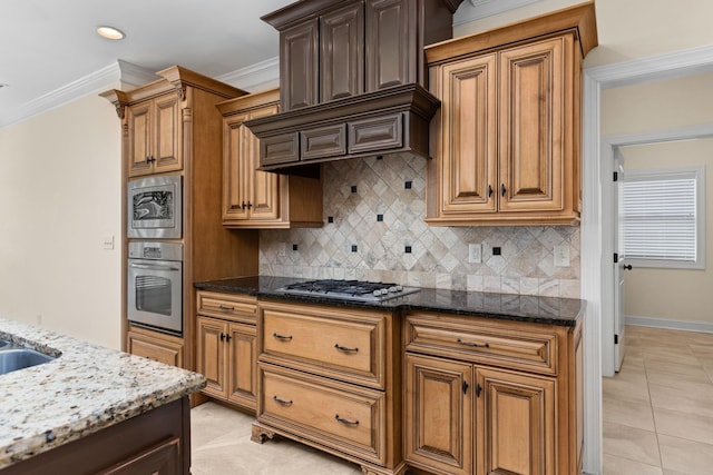 kitchen with tasteful backsplash, crown molding, stone countertops, and appliances with stainless steel finishes