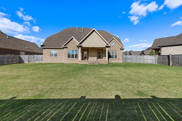 back of house with a lawn and ceiling fan