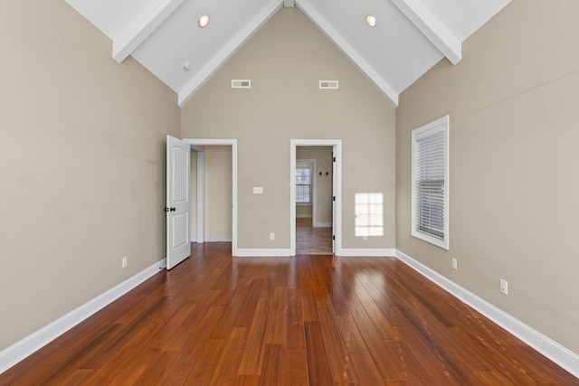 unfurnished bedroom with beamed ceiling, high vaulted ceiling, and dark wood-type flooring