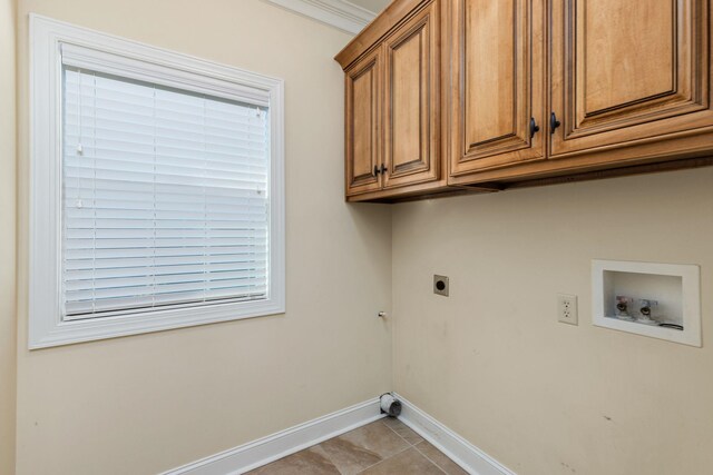 laundry area with electric dryer hookup, cabinets, hookup for a washing machine, ornamental molding, and light tile patterned floors