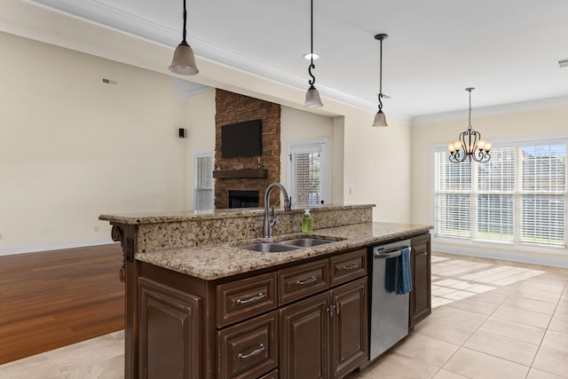 kitchen featuring pendant lighting, dishwasher, a kitchen island with sink, an inviting chandelier, and sink