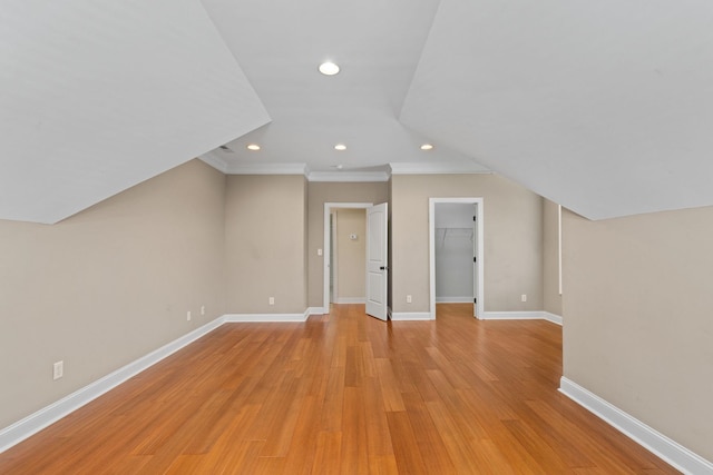 additional living space featuring lofted ceiling and light hardwood / wood-style flooring