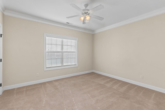 spare room with ceiling fan, crown molding, and light carpet