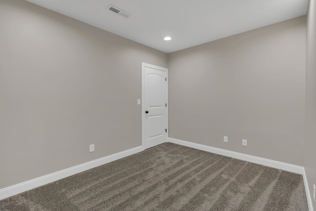 spare room with dark colored carpet, recessed lighting, visible vents, and baseboards