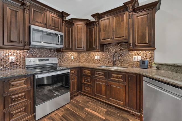 kitchen with tasteful backsplash, appliances with stainless steel finishes, dark wood-type flooring, and a sink