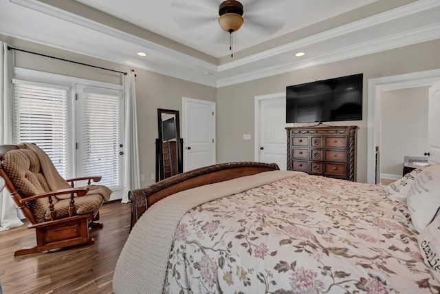 bedroom featuring access to exterior, a tray ceiling, crown molding, and wood finished floors