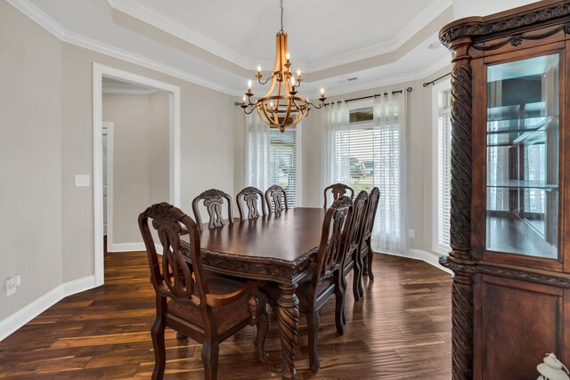 dining space featuring dark wood-style floors, a tray ceiling, and crown molding