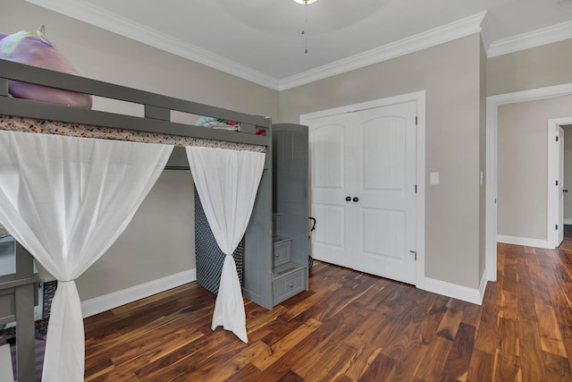 unfurnished bedroom featuring a closet, crown molding, baseboards, and wood finished floors