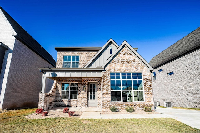 view of front of house with a porch, central air condition unit, and a front yard