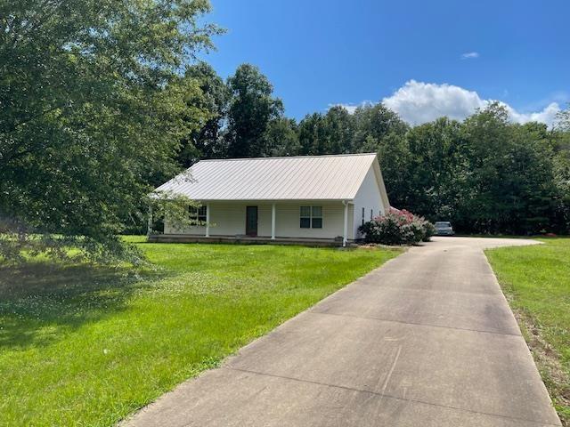  - view of front of home with a front yard, metal roof, and a porch