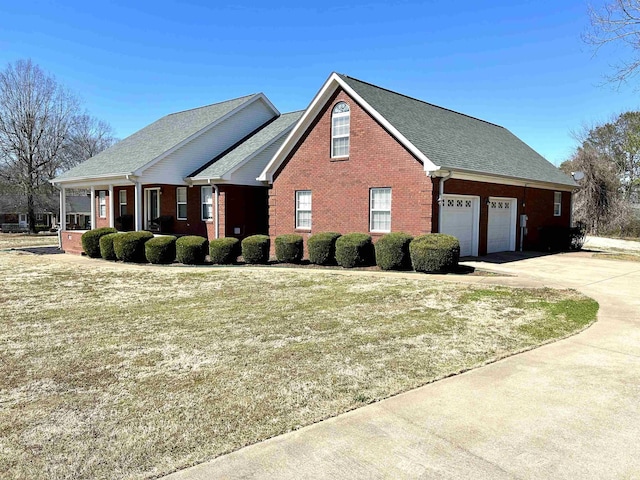 view of front of house with driveway, brick siding, and an attached garage