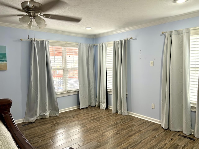 unfurnished bedroom featuring crown molding, visible vents, dark wood-type flooring, a textured ceiling, and baseboards