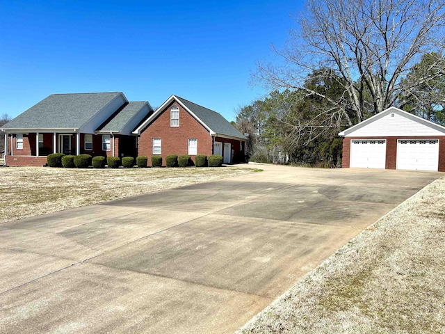 exterior space with a garage, brick siding, and an outbuilding