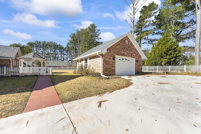 view of property exterior with a gazebo, a garage, and a lawn