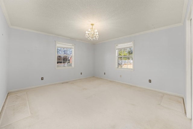 empty room featuring light carpet, ornamental molding, a textured ceiling, and an inviting chandelier