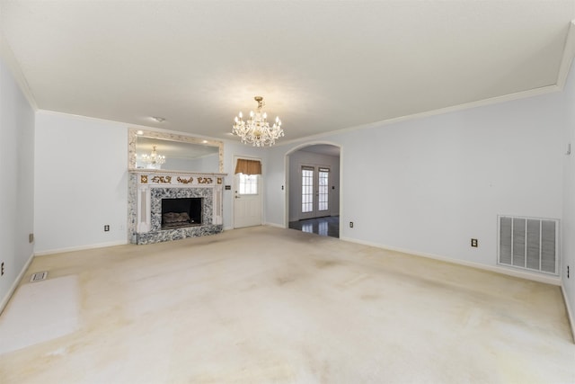 unfurnished living room with a tile fireplace, crown molding, french doors, and carpet