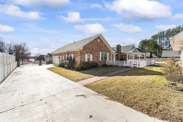 view of front of home with a front yard, a gazebo, and a garage