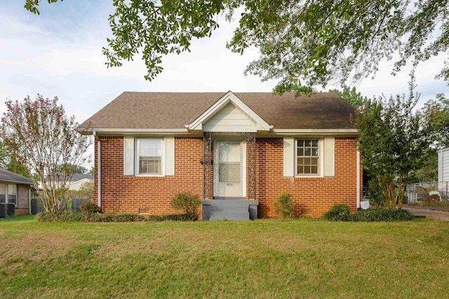 bungalow-style home featuring a front yard and cooling unit