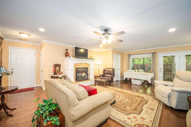 living room featuring ceiling fan, crown molding, a textured ceiling, and hardwood / wood-style flooring