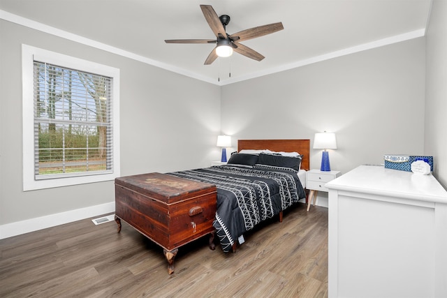 bedroom with ceiling fan, hardwood / wood-style flooring, and ornamental molding