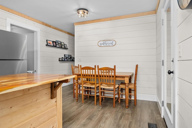 dining area featuring wood walls and hardwood / wood-style flooring