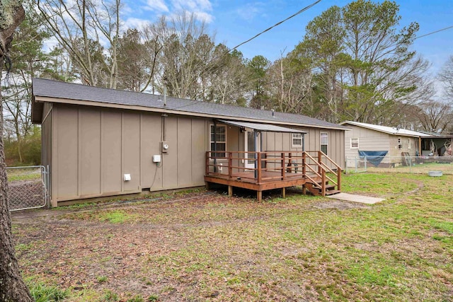 rear view of house with a lawn and a deck