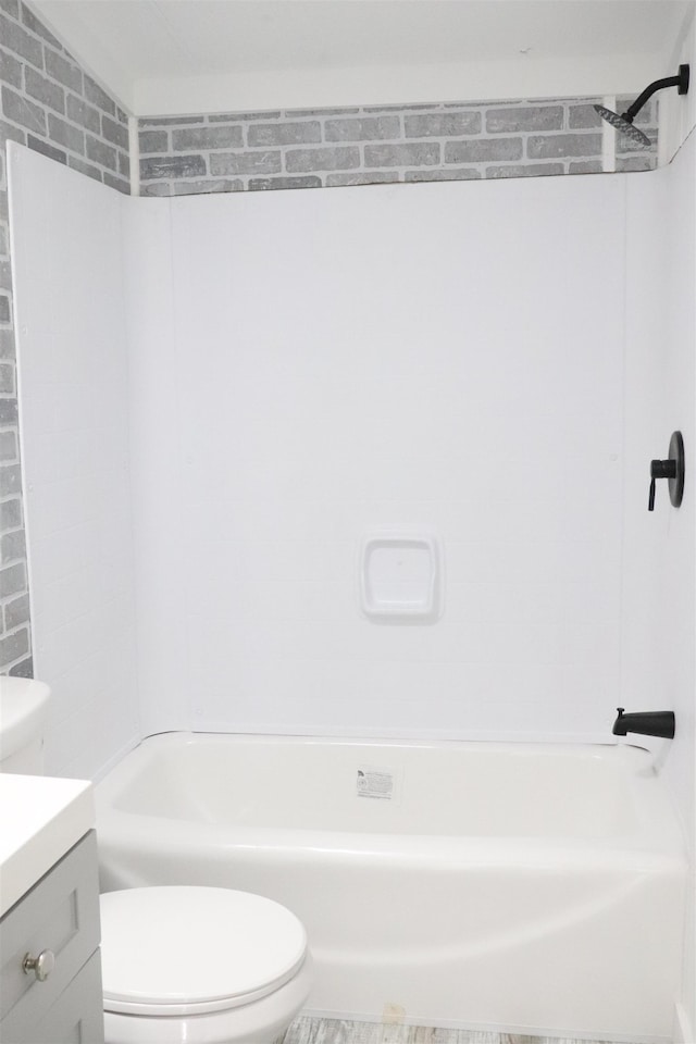  - bathroom featuring toilet, vanity, and shower / washtub combination