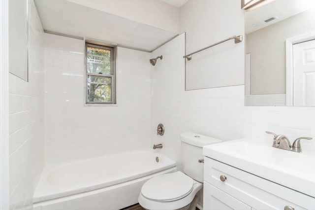 full bathroom featuring tiled shower / bath combo, backsplash, toilet, vanity, and tile walls