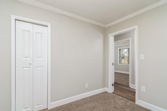 unfurnished bedroom with carpet flooring, a closet, and ornamental molding