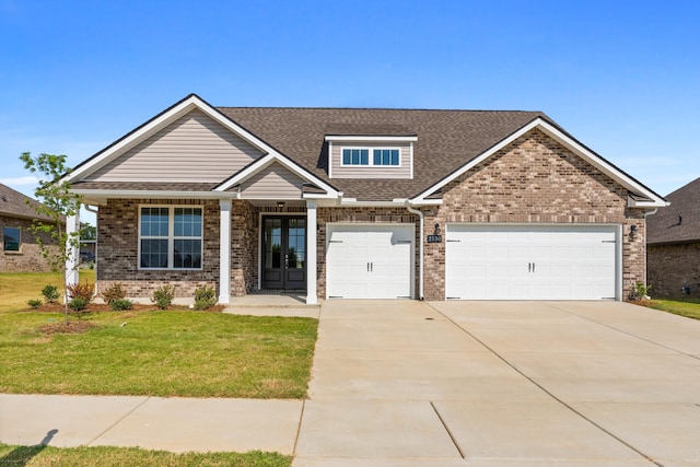 craftsman-style house with a garage, a front yard, and french doors