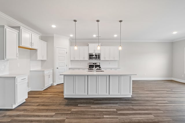 kitchen featuring stainless steel appliances, white cabinetry, a center island with sink, and sink