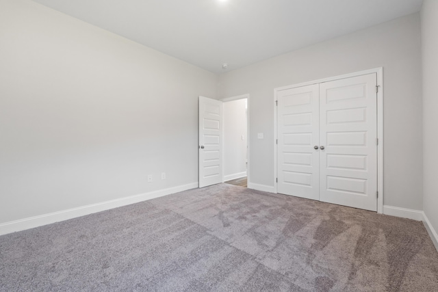 unfurnished bedroom with a closet and carpet floors