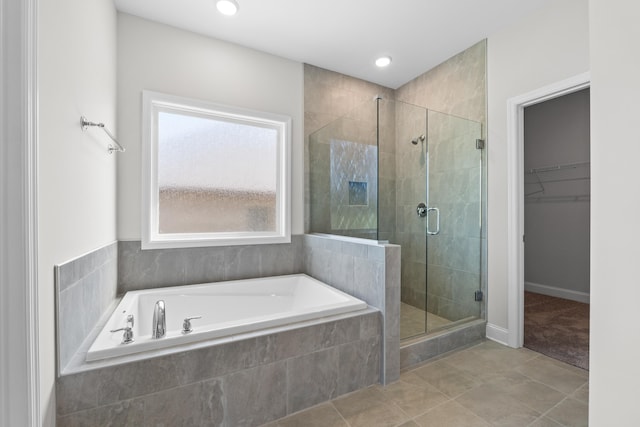 bathroom featuring plus walk in shower, tile patterned floors, and a wealth of natural light