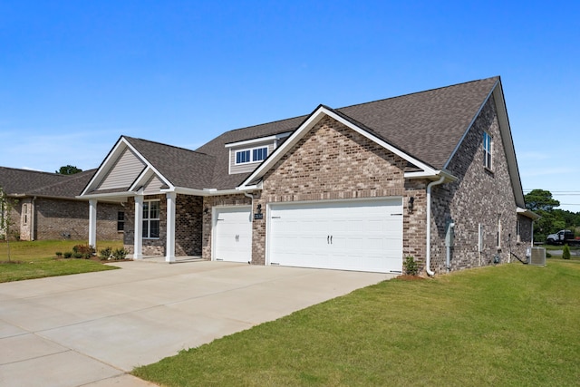 craftsman house with central AC unit, a front yard, and a garage