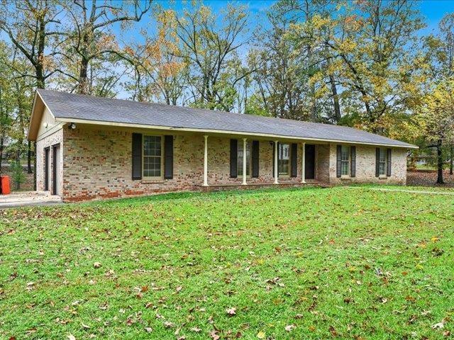 ranch-style home featuring a garage and a front lawn