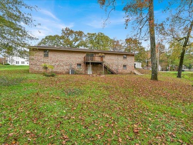 back of property with a yard and a wooden deck