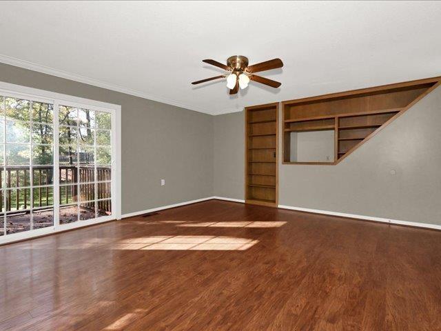 unfurnished living room with hardwood / wood-style flooring, ceiling fan, and crown molding