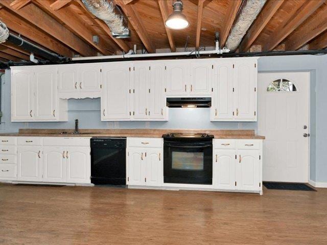 kitchen with sink, white cabinets, black appliances, and dark hardwood / wood-style floors