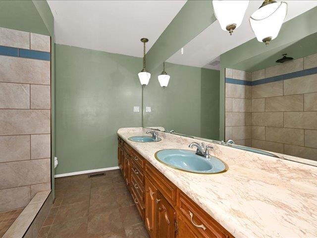 bathroom featuring a tile shower and vanity