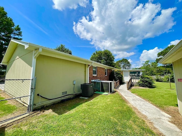 view of property exterior with a yard, cooling unit, and fence