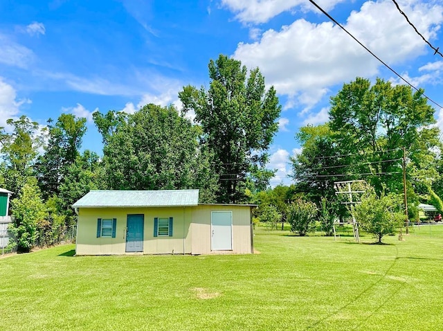 exterior space with a front yard, fence, and an outbuilding
