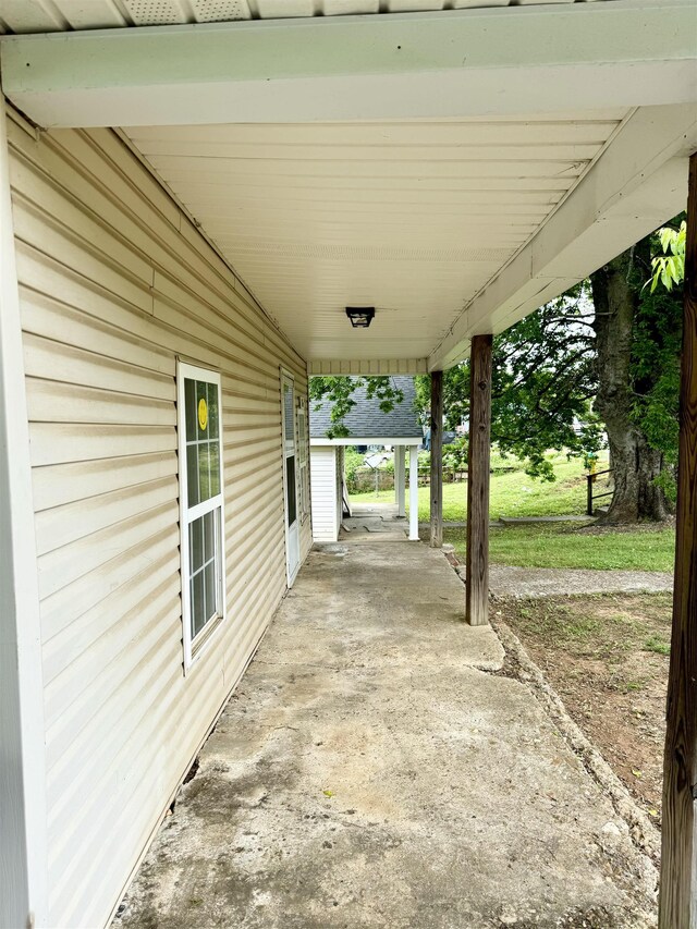  - view of patio / terrace featuring covered porch and an attached carport