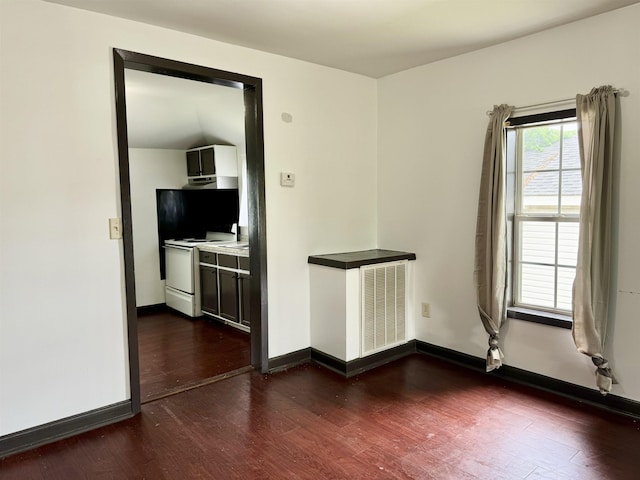empty room featuring baseboards, dark wood-style floors, and visible vents