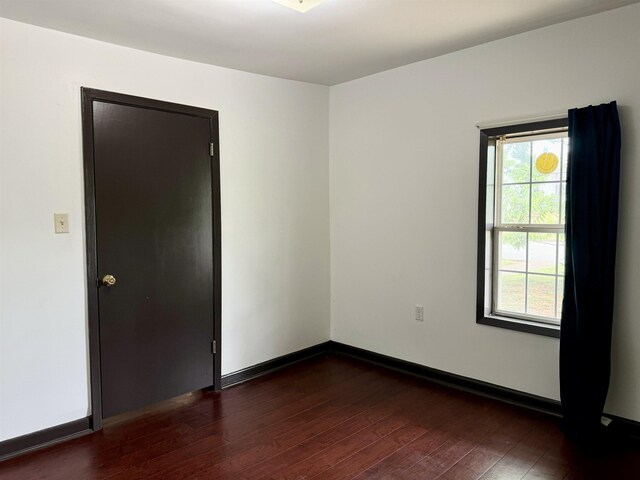  - unfurnished room with baseboards, plenty of natural light, and wood-type flooring