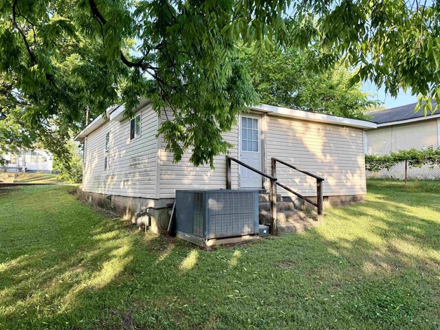  - view of home's exterior with a yard, fence, and central AC unit