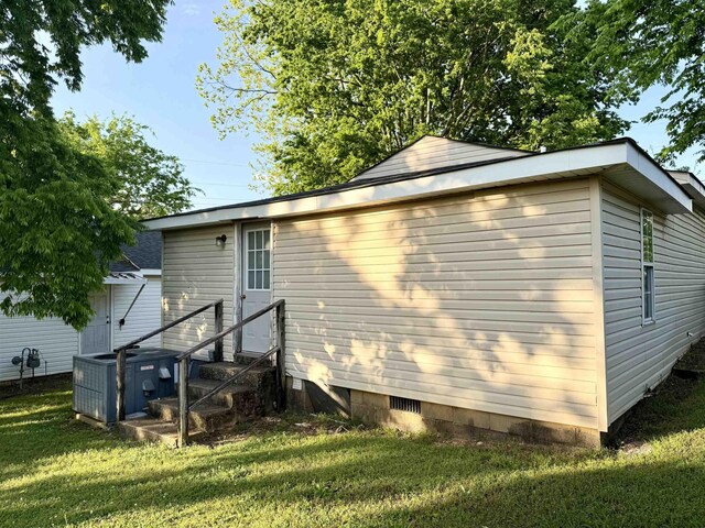  - view of side of home featuring central air condition unit, a lawn, and crawl space